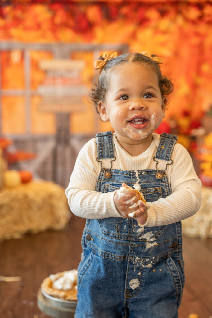 Autumn themed photoshoot idea with baby covered in whipped cream and pumpkin pie