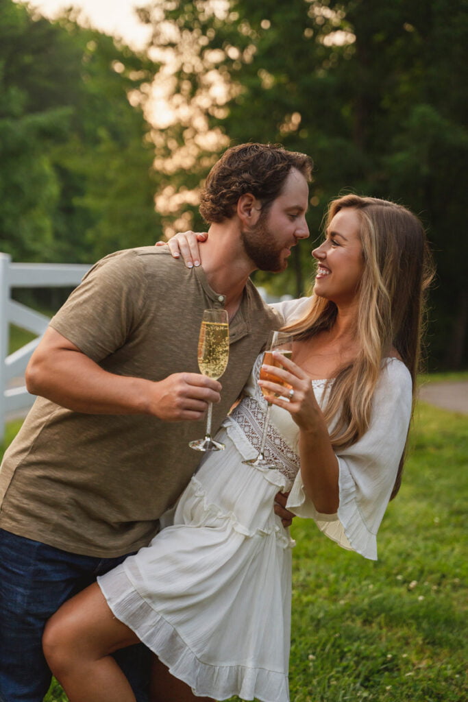 Engagement shoot of a cute couple drinking champagne together and holding glasses